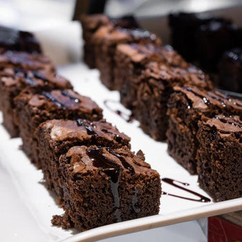 Chocolate chunk brownies recipe by oooflavors with fudgy texture and melted chocolate chunks on a baking tray