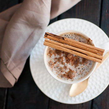Creamy cinnamon keto coffee in a mug with frothy top, made with butter and MCT oil for energy and fat burning