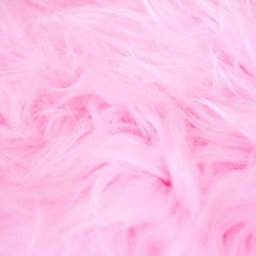 Fresh pink and blue cotton candy spinning on a cone with fluffy sugar strands in a cotton candy machine.