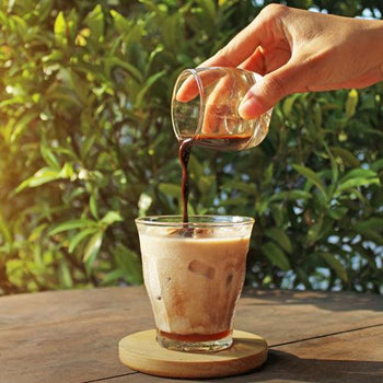 Creamy honey vanilla latte with milk foam and honey drizzle in a glass mug with espresso and steamed milk.