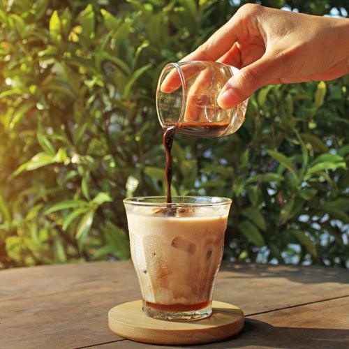 Creamy honey vanilla latte with milk foam and honey drizzle in a glass mug with espresso and steamed milk.
